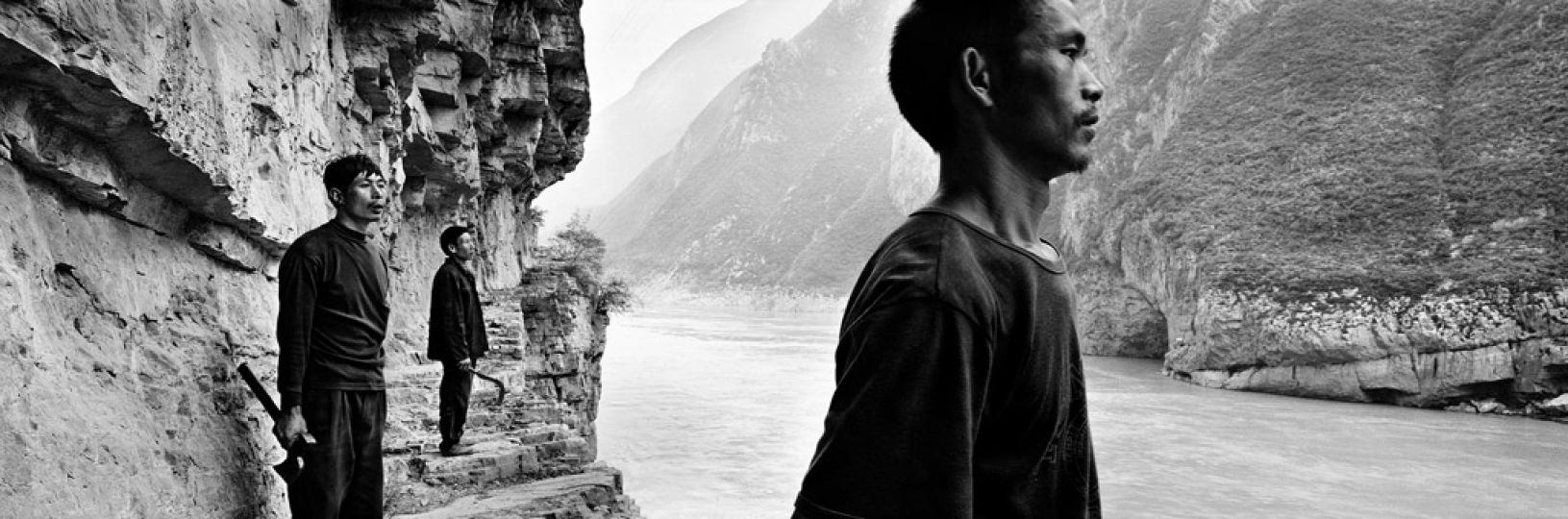 © Zeng Nian, Trois bûcherons sur l’ancienne piste creusée dans le rocher surplombant la porte de Kui (kuimen) de 3 Gorges, Chine. Septembre 1996.